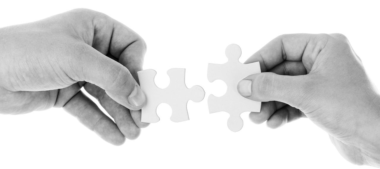 Two hands assembling puzzle